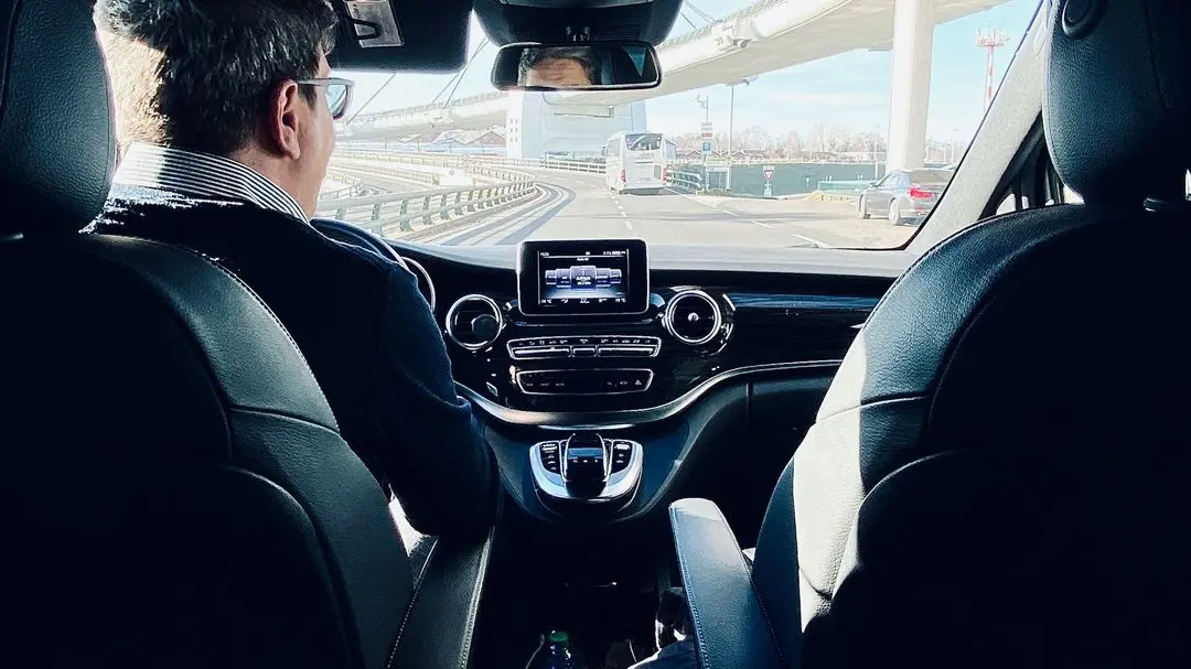 man in black suit driving car during daytime